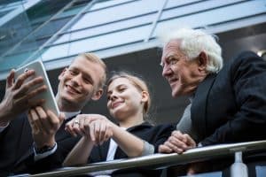 Gemischtes Team betrachtet Smartphone