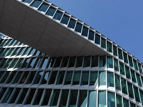Frankfurt – Moderne Büroarchitektur Moderne Frankfurter Bürogebäude mit überbrückender Glasfassade gegen den blauen Himmel.