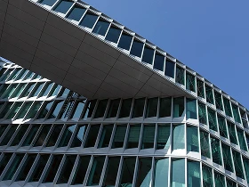 Frankfurt – Moderne Büroarchitektur Moderne Frankfurter Bürogebäude mit überbrückender Glasfassade gegen den blauen Himmel.