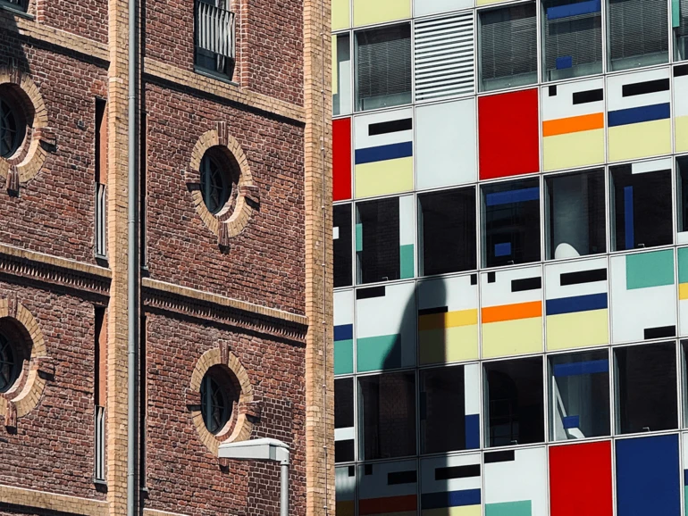 Düsseldorf – Architekturkontraste im Medienhafen Historisches Backsteingebäude neben einer modernen, farbenfrohen Fassade im Düsseldorfer Medienhafen.