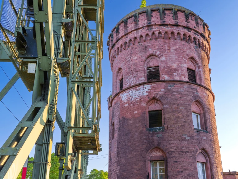Mainz – Historischer Brückenturm am Rheinufer Alter roter Brückenturm aus Sandstein neben moderner Industriekonstruktion am Mainzer Rheinufer.