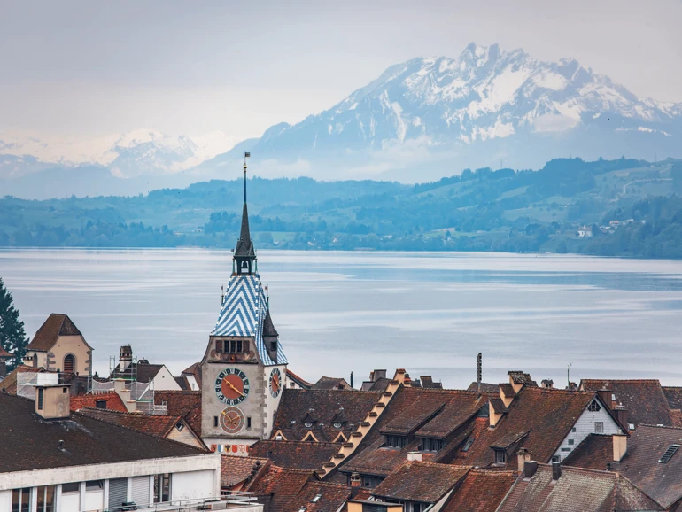 Baar – Altstadt und Zugersee mit Alpenpanorama Blick über die Dächer von Baar zum Zugersee und den schneebedeckten Alpen.