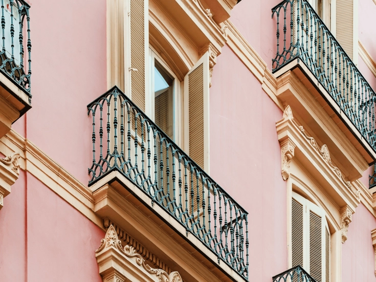 Valencia – Historische Balkone Fassade eines historischen Gebäudes in warmen Farben mit verzierten Eisenbalkonen.